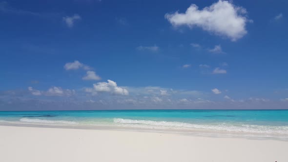 Tropical overhead abstract shot of a white sand paradise beach and aqua blue water background in 4K