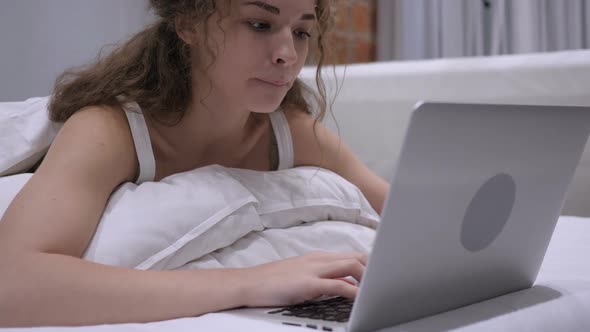 Thinking Pensive Female in Bed Working on Laptop Work