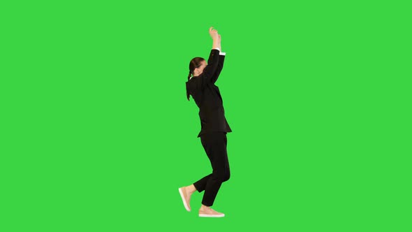 Young Woman in Office Suit Walks Dancing Raising Her Arms on a Green Screen Chroma Key