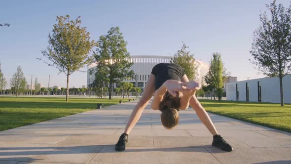 Sports Woman Makes Morning Jog and Physical Exercises In  Park