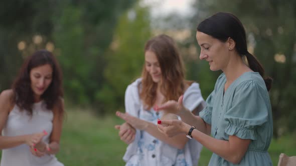 A Group of Young Women in Nature in the Park Conducts a Master Class on Clay Modeling