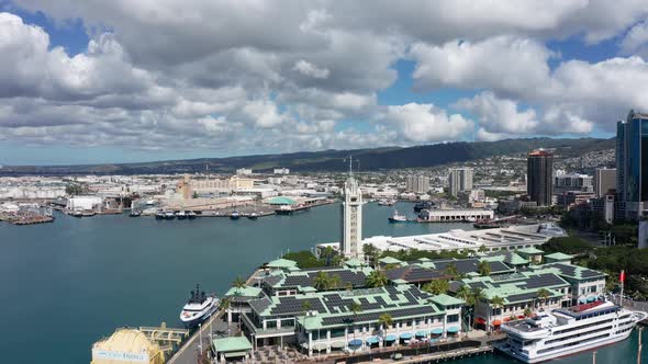 Wide panning aerial shot of the Aloha Tower in the Port of Honolulu on the island of O'ahu, Hawaii.