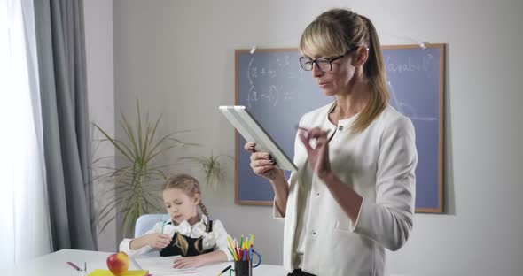 Portrait of Intelligent Middle Aged Caucasian Woman Looking at Camera, Fixing Elegant Eyeglasses and