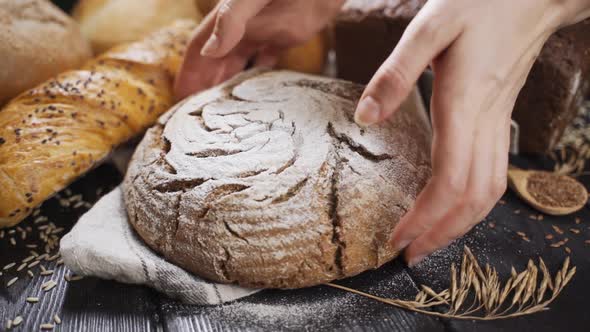 Woman Takes Fresh Bread From the Table. Fresh Homemade Whole Wheat Bread on a Background