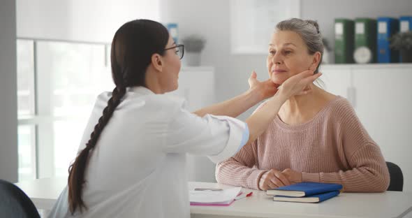 Professional Physician Checking Neck Lymph Nodes of Old Woman
