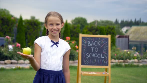 Happy Little Schoolgirl with a Chalkboard Outdoor