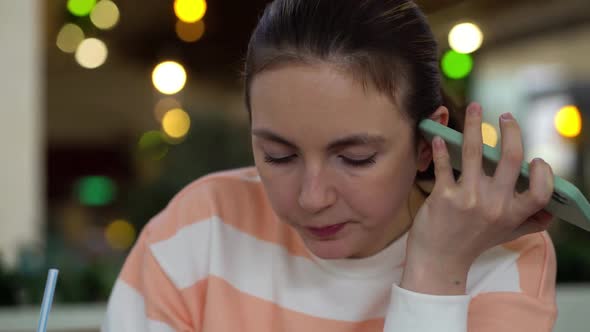 Pretty Woman Eating Salad and Listens to a Voice Message on the Phone