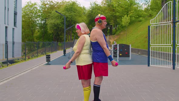 Active Elderly Old Sports Team Grandmother Grandfather Weightlifting Dumbbells Smiling at Camera