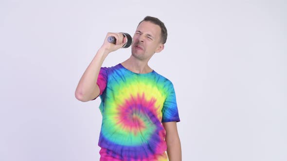 Studio Shot of Man with Tie-dye Shirt Singing with Microphone