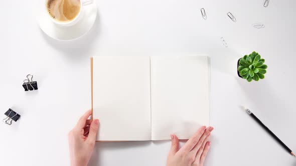 Blank textbook opening with hands. Turning over clean blank paper pages in big notebook.