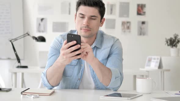 Casual Young Man Using Smartphone Typing Message