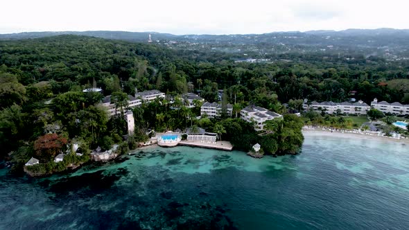 Aerial pan in to resort in Jamaica with pool and beach