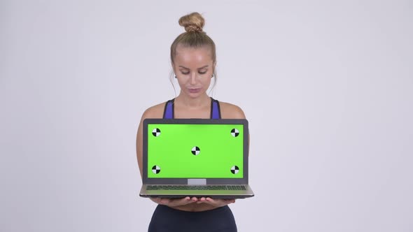 Happy Young Beautiful Blonde Woman Thinking While Showing Laptop