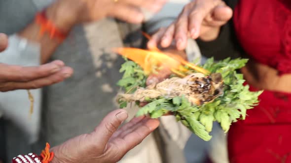 Indian people burning herbs on the riverbank as a purification ritual. alt