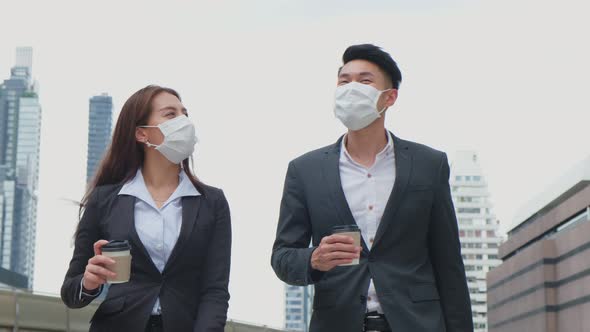 Asian young couple office business people wear face mask, stand outdoor in city with confident face