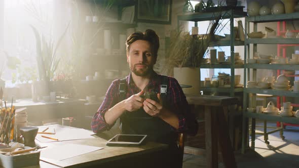 Man Is Drinking Coffee and Looking at Camera