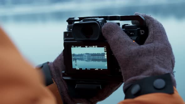 Close Up Camera in Hands Shooting Snowy Lake in Winter Forest