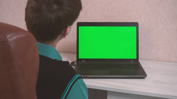 A Man Doing Warm Up Exercises While Sitting at a Laptop Via Video Call in a Protective Face Mask