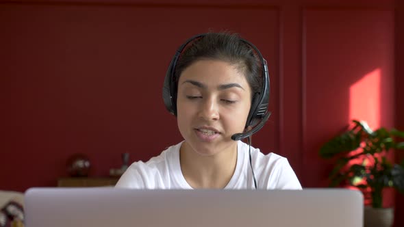 Close - up Indian female student makes conference video call on laptop computer talks 