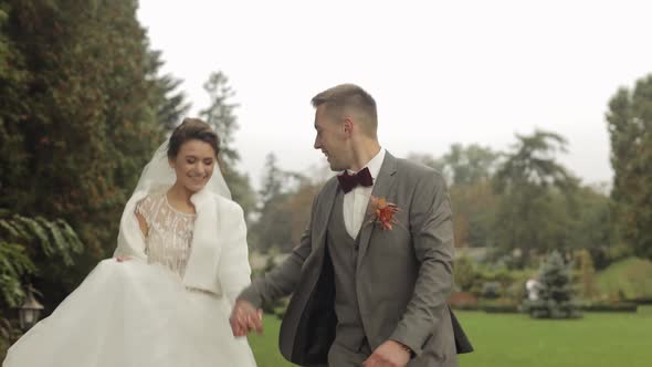 Lovely Newlyweds Caucasian Bride Groom Running in Park Holding Hands Wedding Couple Family