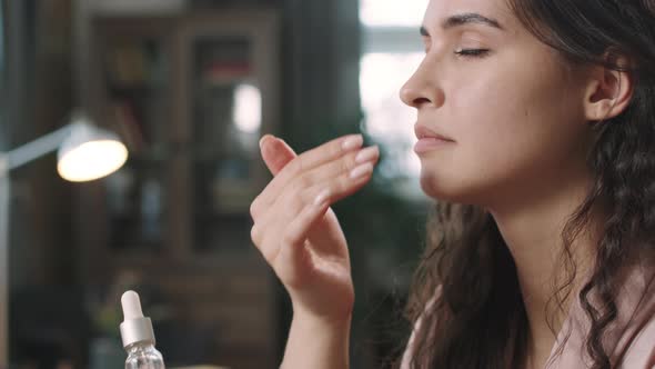 Woman Applying Hydrating Serum On Face