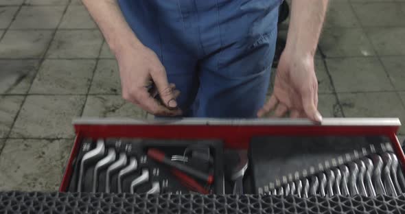 Auto Mechanic Opens And Closes A Box With Working Tools.
