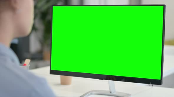 Rear View of African Woman Using Desktop with Green Chroma Key Screen