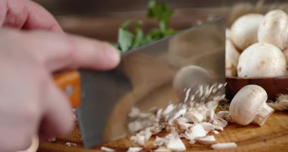 Man's Hand Crushed Fresh Mushrooms on a Cutting Board. 