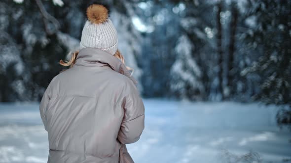 Pleasant Casual Happy Woman with Waving Hair Walking at Winter Forest