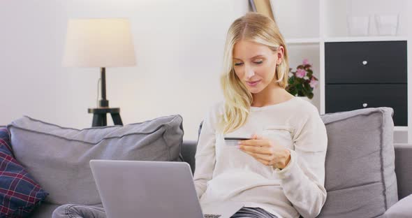 Concentreted Female Sit on Cozy Couch at Home with Laptop on Knees Browsing Internet Happy Girl