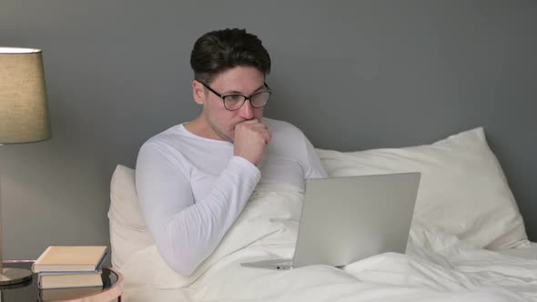 Sick Middle Aged Man with Laptop Coughing in Bed