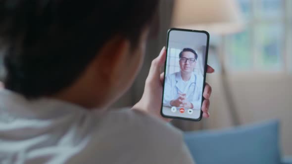 Close Up Of A Man Having Video Call With A Doctor On Smartphone In The Living Room