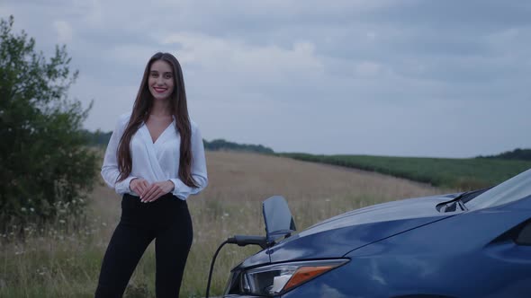 Girl Stands on Her Electric Car That Charges