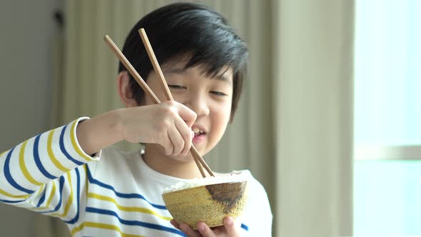 Cute Asian Boy Eating Rice With Chopsticks