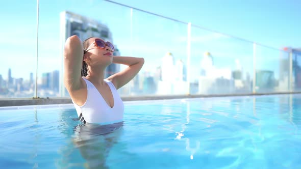 Young asian woman enjoy around outdoor swimming pool for leisure