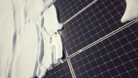 Closeup surface on a house roof covered with solar panels in winter with snow on top.