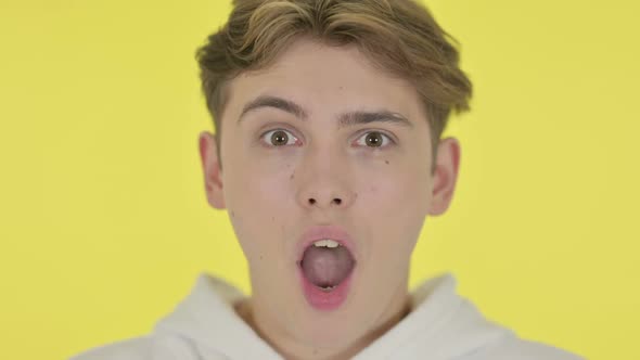 Close Up of Shocked Young Man Yellow Background