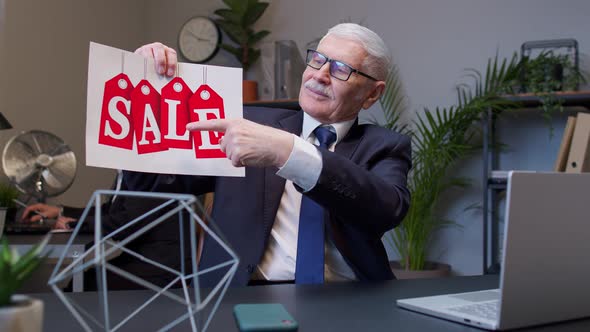 Senior Business Manager Showing Black Friday Sale Word Advertisement Inscriptions Banner in Office