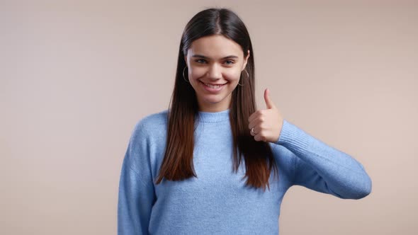 Woman Showing Thumb Up Sign Over Light Background