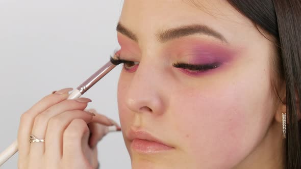 A Professional Makeup Artist Applies Grey Eyeshadow with a Special Brush in a Makeup Studio