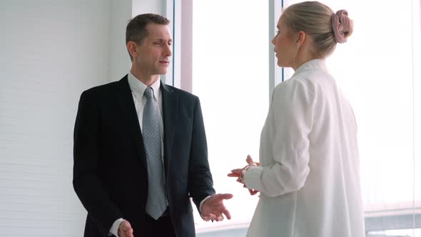 Two Business People Talk Project Strategy at Office