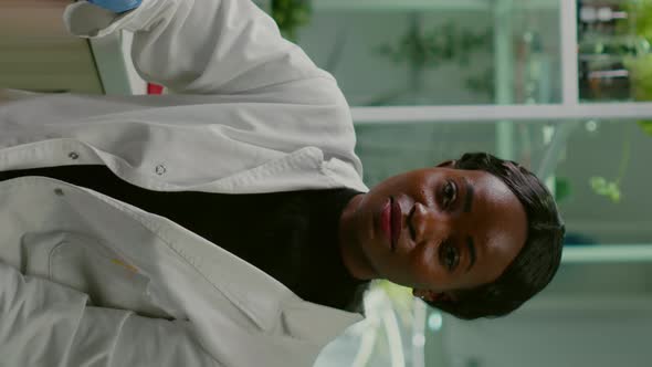 Vertical Video Pov of African Woman Sitting at Desk Table in Pharmaceutical Laboratory