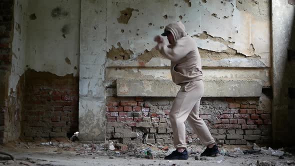 A Young Man Boxing In A Destroyed Building, A Man Performing Boxing Exercises.