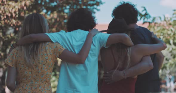 Group of friends hugging each other and walking to a vineyard