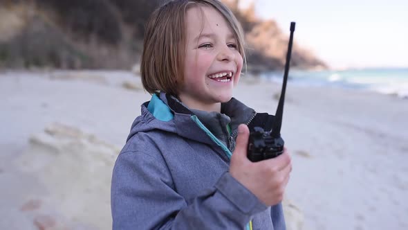 The Boy is Talking on the Radio on the Beach Outdoor