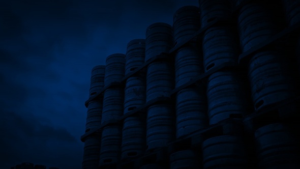 Pan Across Stacked Metal Barrels At Night