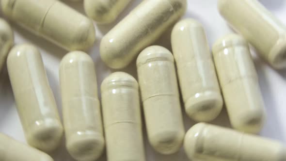 Medication Beige Pills Are Rotating on White Background Closeup View