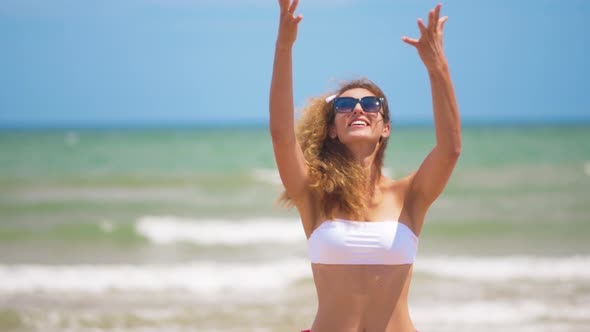 Funny Smiling Girl in Summer Swimwear and Sunsunglasses. Sexy Girl Throws Pineapple on the