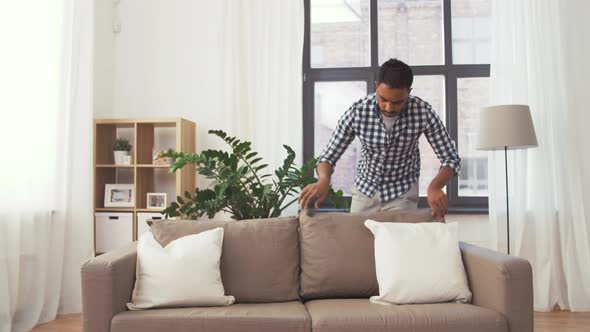 Indian Man Arranging Sofa Cushions at Home 