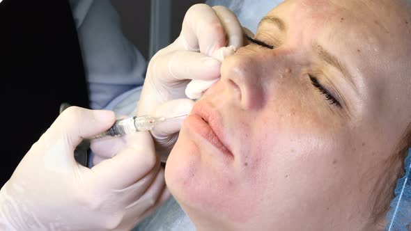 Young Woman with Closed Eyes Getting Facial Botox Injection